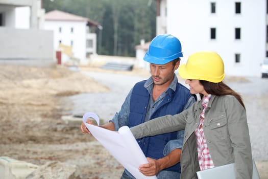 Team of architects checking plans on site