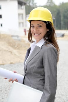Businessman with helmet checking site under construction