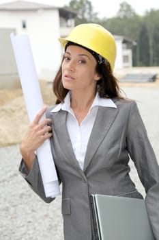 Businessman with helmet checking site under construction