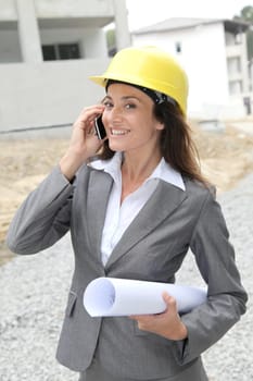 Businessman with helmet checking site under construction