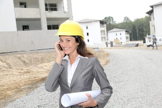 Businessman with helmet checking site under construction