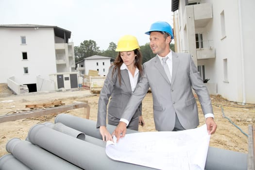 Team of architects checking plans on site