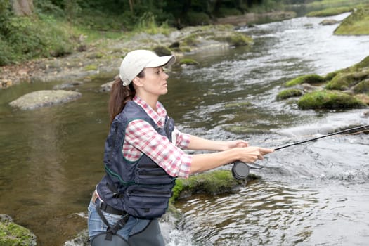 woman with fly fishing rod in river