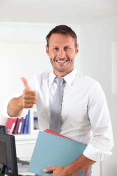 Happy businessman with thumb up in the office