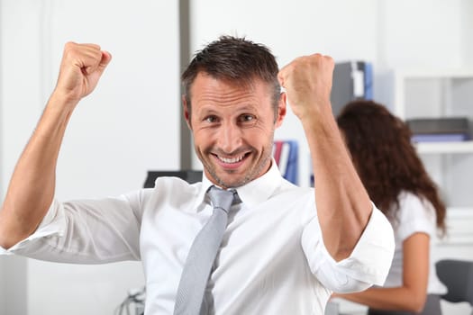 happy businessman with arms up