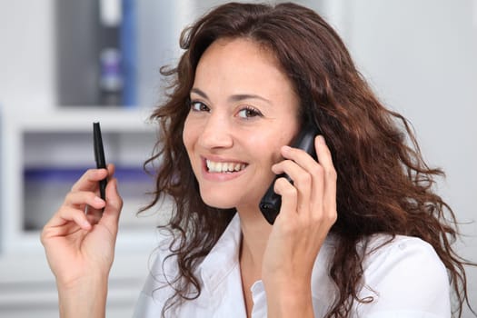 Closeup of businesswoman in the office talking on the phone