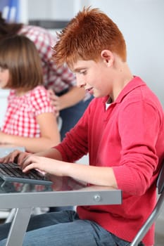 Teacher and children learning to use computer