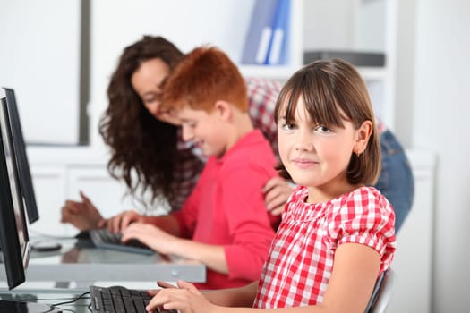 Teacher and children learning to use computer