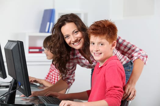 Teacher and children learning to use computer