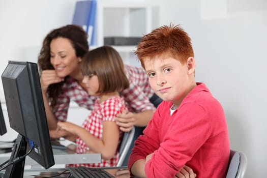 Teacher and children learning to use computer