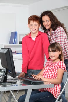 Teacher and children learning to use computer