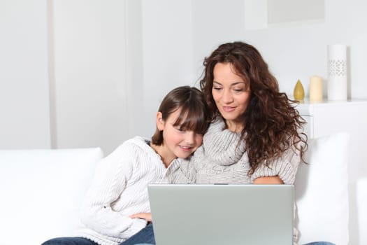 Closeup of mother and child at home with laptop computer