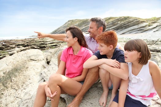 Parents and children sitting by the sea