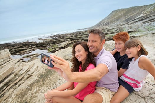 Father taking picture of the family in front of the sea