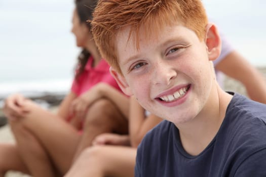 Young boy looking at camera and family in background