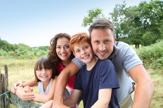 Family leaning on a fence