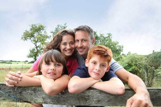 Family leaning on a fence