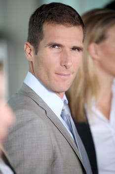 Smiling businessman in front of group