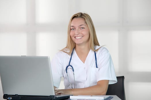 Beautiful smilng nurse working in the office