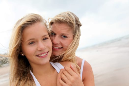Blond woman and young girl on a sandy beach