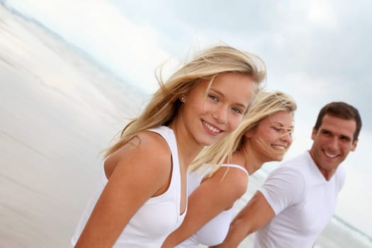 Family walking hand to hand on a sandy beach