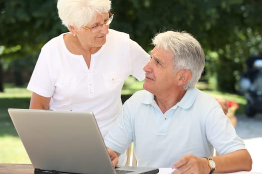 Senior couple using laptop computer at home