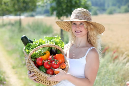 Beautiful woman holding basket of fresh vegetables