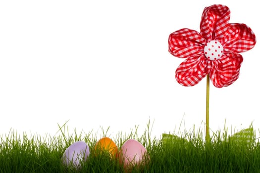 Three pastel-colored Easter eggs in grass with