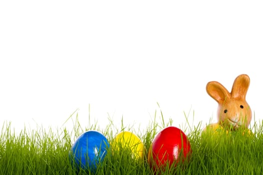 Little Easter bunny with easter eggs in grass