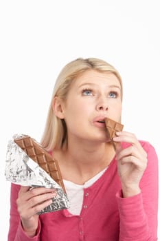 Guilty Looking Young Woman Eating Big Bar Of Chocolate In Studio