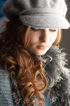Fashionable Teenage Girl Wearing Cap And Knitwear In Studio