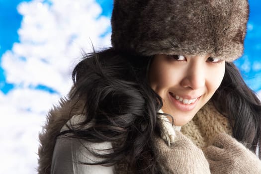 Young Woman Wearing Warm Winter Clothes And Fur Hat In Studio