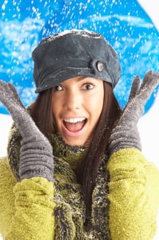 Young Woman Wearing Warm Winter Clothes And Hat In Studio