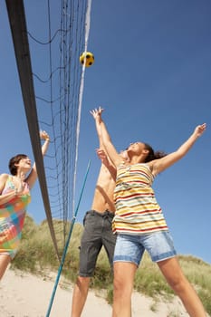 Group Of Teenage Friends Playing Volleyball On Beach