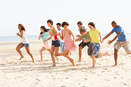 Group Of Friends Running Along Beach Together