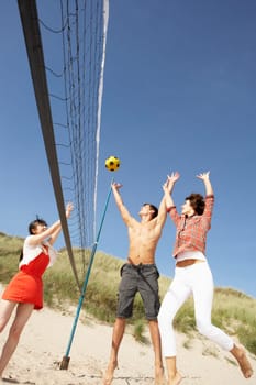 Group Of Friends Playing Volleyball On Beach