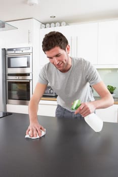 Young Man Cleaning Modern Kitchen