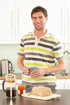 Young Man Preparing Breakfast In Modern Kitchen