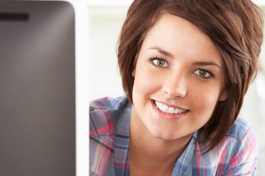 Young Woman Using Computer In Modern Kitchen