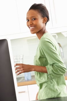 Young Woman Using Computer In Modern Kitchen