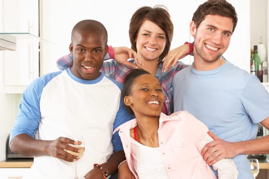 Group Of Young Friends Enjoying Glass Of Wine In Modern Kitchen