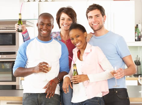 Group Of Young Friends Enjoying Drink In Modern Kitchen