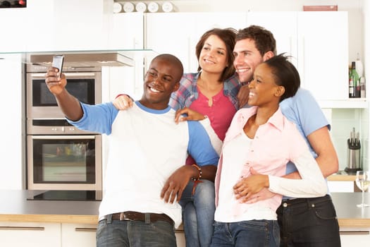 Group Of Young Friends Taking Photo In Modern Kitchen