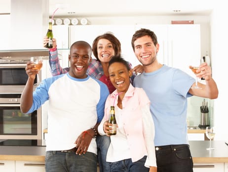 Group Of Young Friends Enjoying Drink In Modern Kitchen