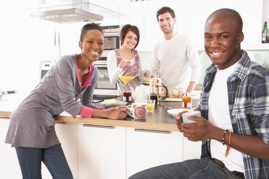 Group Of Young Friends Preparing Breakfast In Modern Kitchen