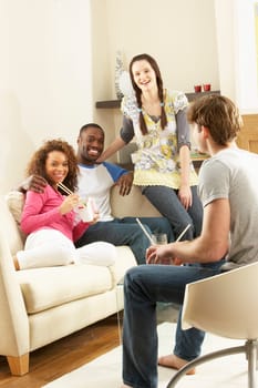 Group Of Friends Enjoying Chinese Takeaway Meal At Home