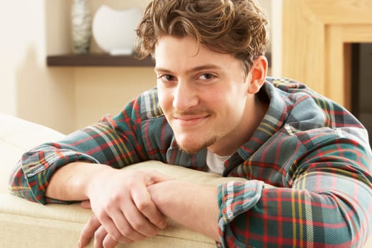 Man Relaxing On Sofa At Home
