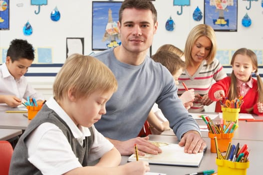 Group Of Primary Schoolchildren And Teacher Having lesson In Classroom