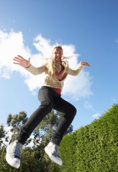 Young Woman Jumping On Trampoline Caught In Mid Air