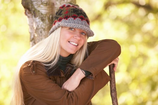Young Woman Outdoors Walking In Autumn Woodland Holding Walking Stick